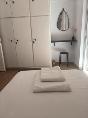 A bedroom with a bed, a wardrobe, a mirror, a small stool, and a shelf. - Casa Dili Stylish 2BR Apartment (Athens)