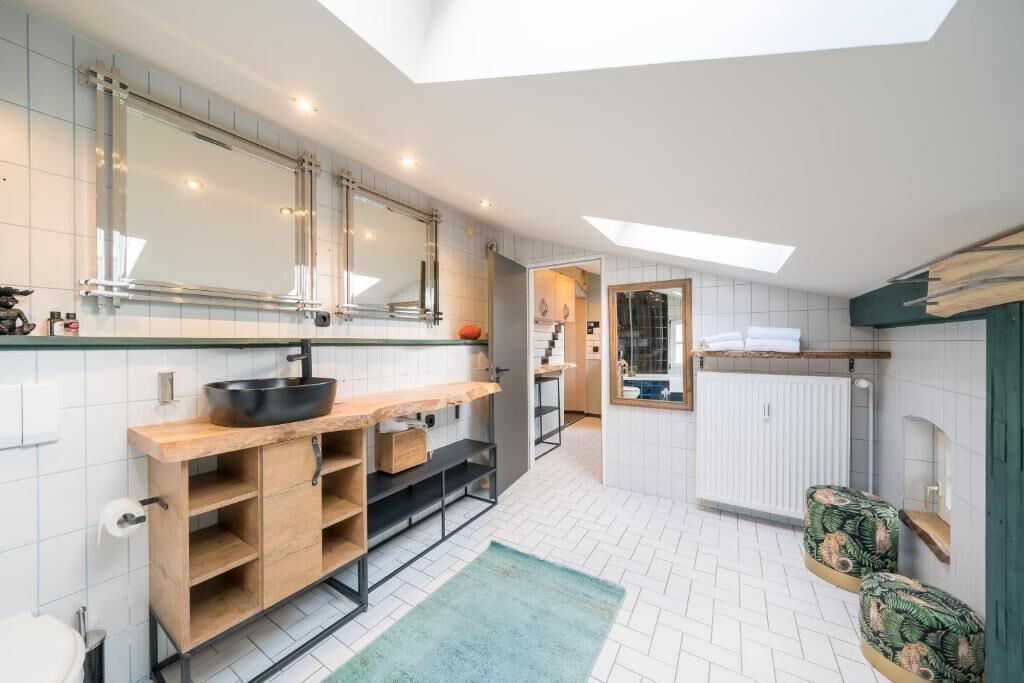 Eine moderne Küche mit Oberlicht, Holzschränken und einem großen Spiegel.