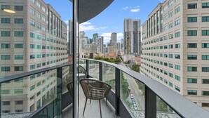 A balcony with a view of a cityscape, featuring modern buildings and a clear sky. - Condo First Downtown Miami (Miami)