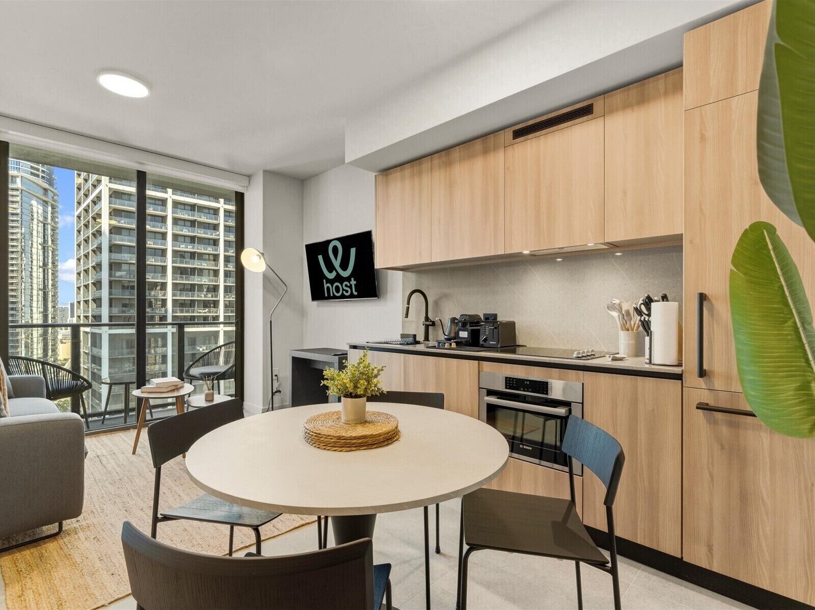 A modern kitchen with wooden cabinets, a Bosch oven, and a dining area with a round table and chairs.