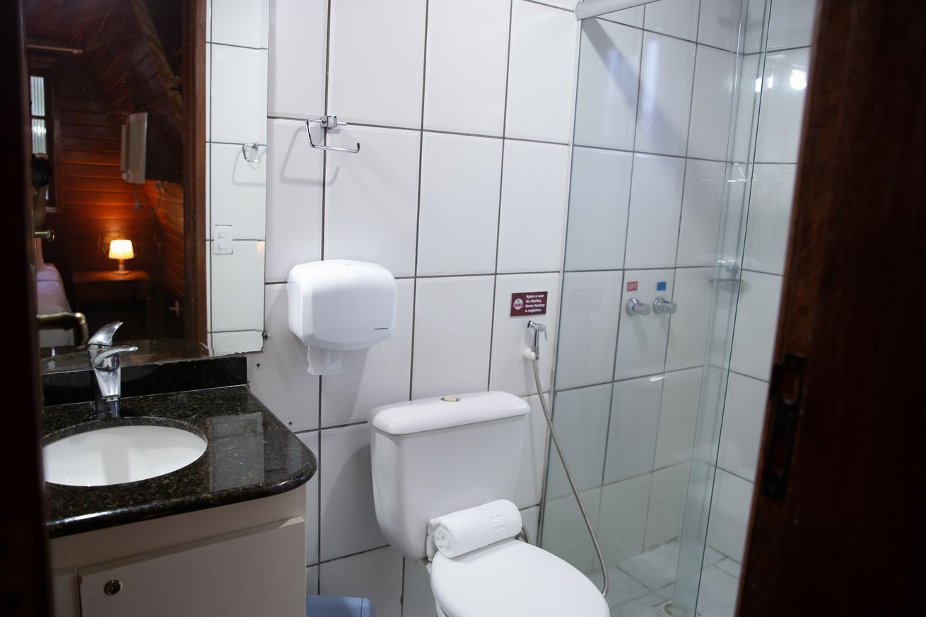 Une salle de bain équipée d’un lavabo, de toilettes et d’une douche à parois en verre.
