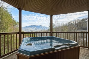 A hot tub on a wooden deck with a mountain view. - Gatlinburg*Amazing View*Sleeps 11*Hot tub (GATLINBURG)
