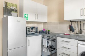 Une cuisine moderne équipée d’un réfrigérateur, d’un four à micro-ondes, d’un four et d’un coin café.