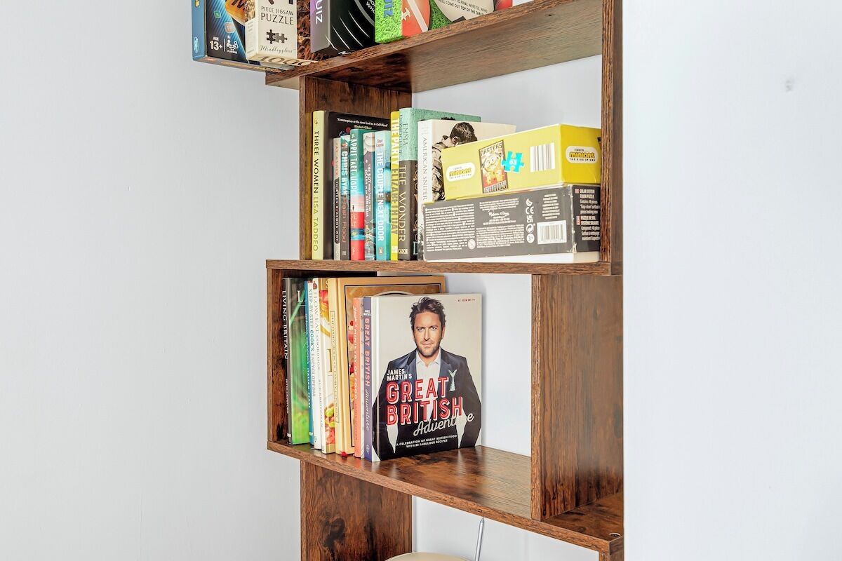 Una estantería con varios libros y una revista.