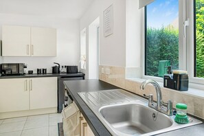 A modern kitchen with a sink, countertop, and cabinets.