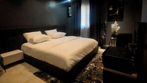Une chambre à coucher moderne avec un grand lit, une commode et un bureau.
