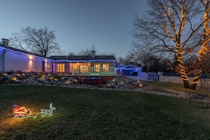A house with a well-lit exterior, a stone pathway, and a tree with lights. - Tranquil Retreat in Central Istria. (Pazin)