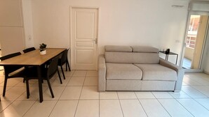 Un soggiorno moderno con un divano, un tavolo da pranzo con sedie e un piccolo tavolino.