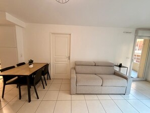 A modern living room with a sofa, a dining table with chairs, and a small side table. - Antibes near the beach with parckage (Antibes)