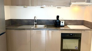 Una cucina moderna con elettrodomestici in acciaio inossidabile, tra cui una lavastoviglie, un tostapane e una macchina per il caffè.