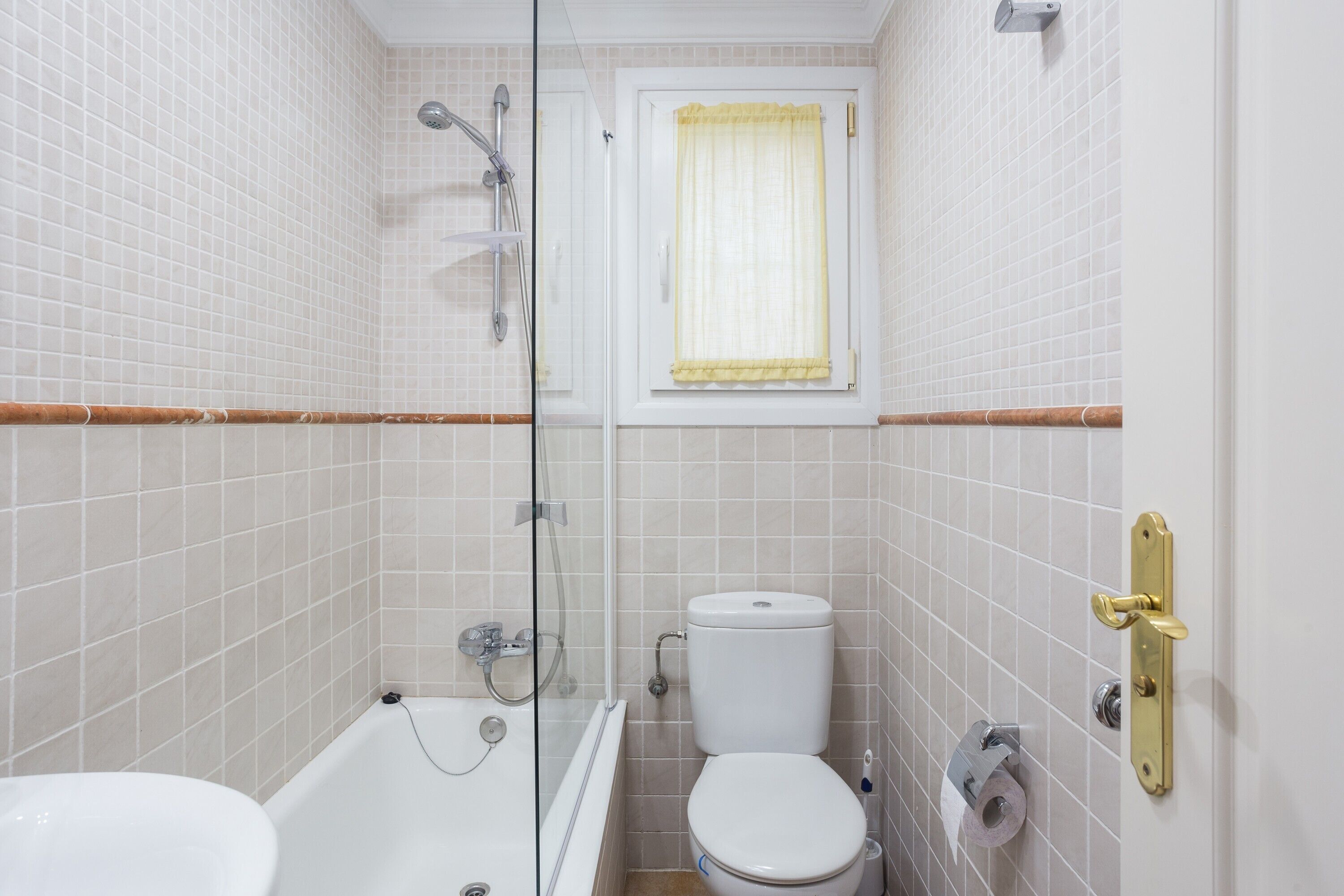 Un baño con bañera, inodoro y cabina de ducha de vidrio.