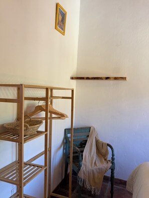 Een kamer met een houten plankensysteem, een stoel en een klein tafeltje.