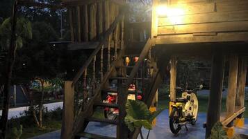 A wooden structure with a staircase, a motorcycle, and a potted plant.