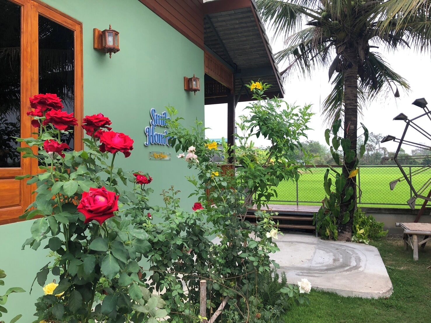 A building with a green exterior, a wooden door, and a sign that reads "Sun House."
