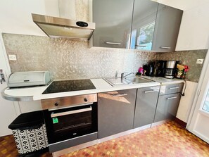 A compact kitchen with a built-in oven, a coffee maker, and a trash bin. - Beautiful "Keristin" family home in Concarneau (Concarneau)
