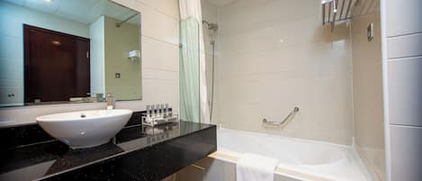 A modern bathroom with a double sink, a bathtub, and a shower.