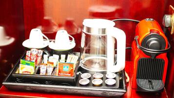 Una cafetera con una bandeja de bolsitas de té Lipton y paquetes de té Lipton English Breakfast.