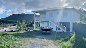 Une maison à deux étages avec une voiture garée dans l’allée.