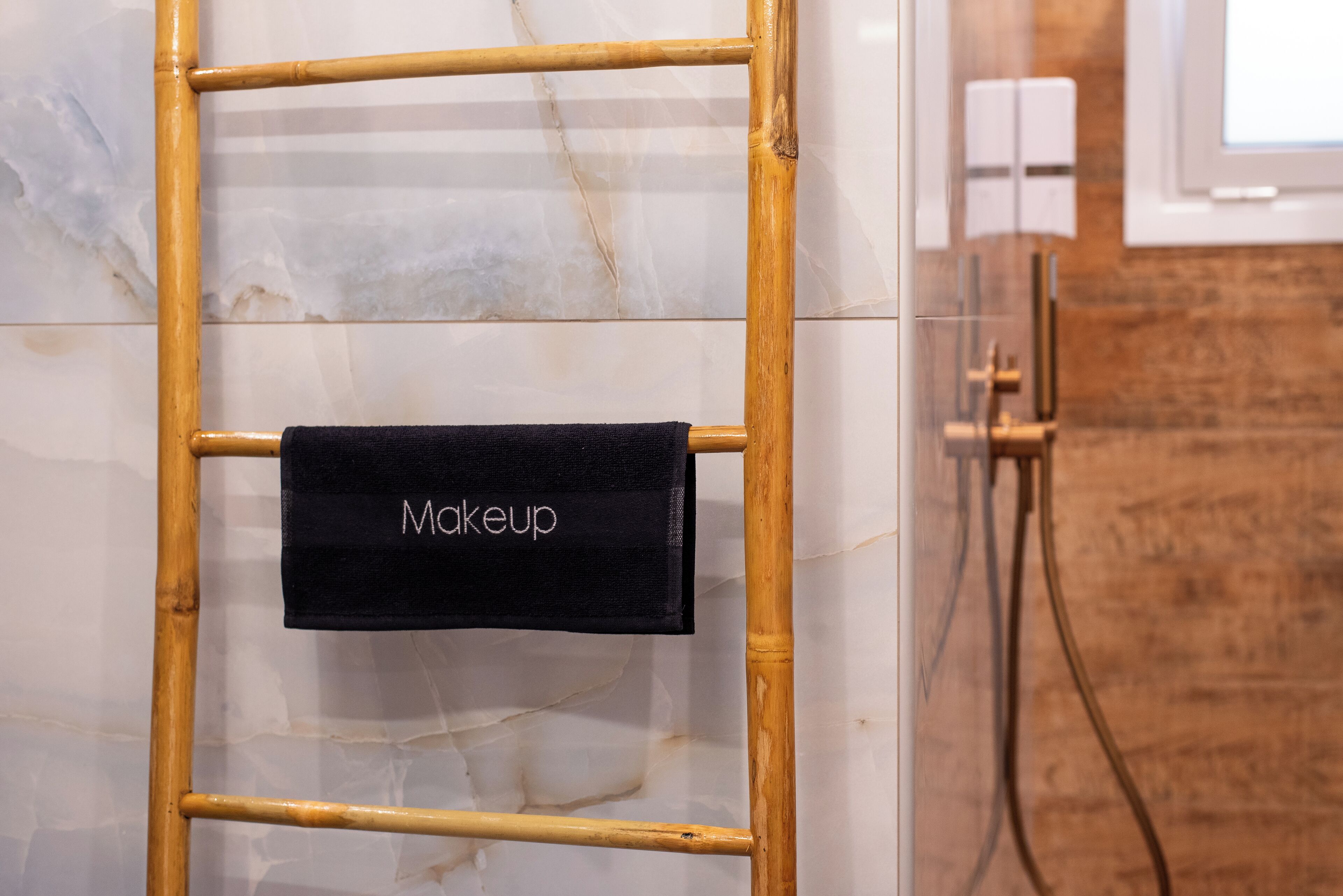 Baño con una escalera de madera y un perchero con la etiqueta 'Maquillaje'.