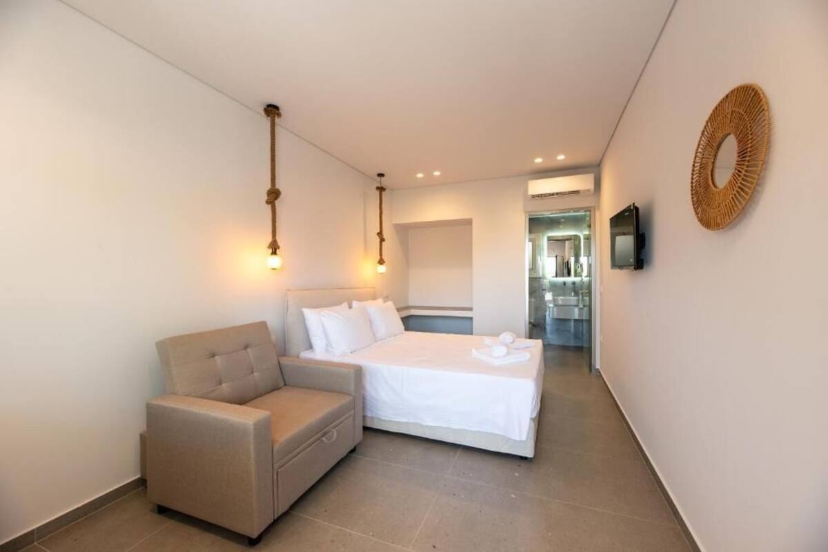 Une chambre d’hôtel équipée d’un lit, d’un canapé, d’une télévision et d’un élément décoratif fixé au mur.