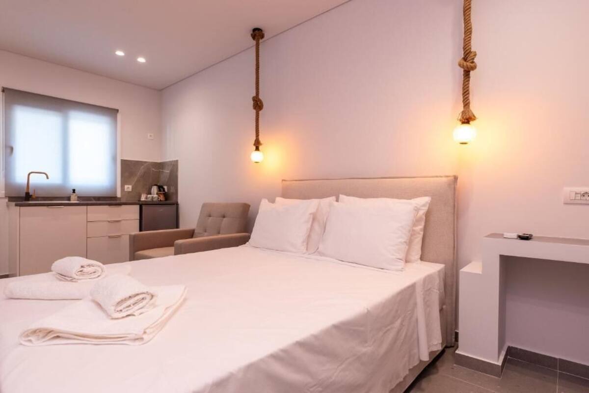 Une chambre d’hôtel moderne dotée d’un grand lit, d’un coin salon, d’un petit bureau et d’une salle de bain.