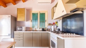 Eine Küche mit Kühlschrank, Mikrowelle, Herd und Schränken.
