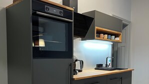 Ett modernt kök med en inbyggd ugn, mikrovågsugn och kaffebryggare.