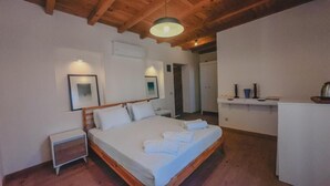 A bedroom with a wooden bed, bedside tables, a small desk, and a white wardrobe. - Gulhiz (Datca)