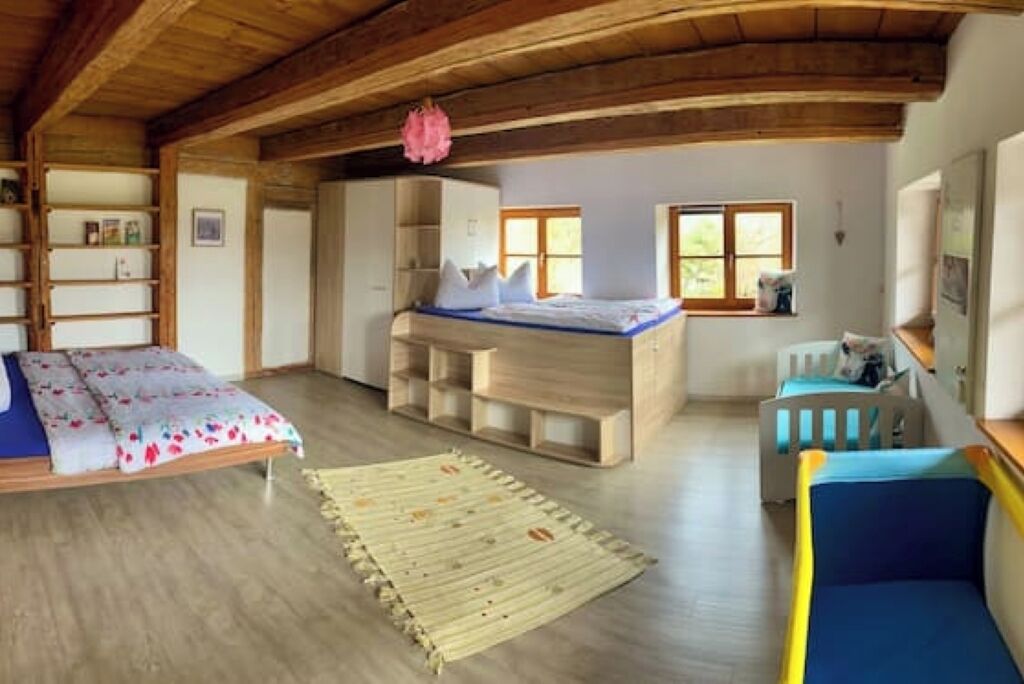 A cozy room with a bed, a crib, and built-in shelves.