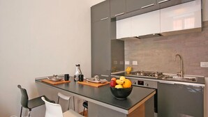 Et moderne køkken med en central ø, indbygget komfur og vask.