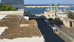 Une vue sur la côte, avec un port de plaisance, des bâtiments et un ciel dégagé.
