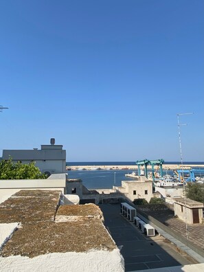 Une vue sur la côte, avec un port de plaisance, des bâtiments et un ciel dégagé.