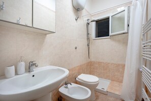 Ein Badezimmer mit Waschbecken, Bidet, Toilette und Dusche.