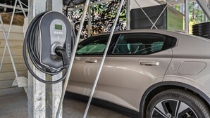 Ein Auto wird an einer Ladestation aufgeladen, mit einem digitalen Display und einem angeschlossenen Kabel.