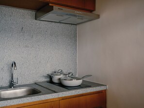 A kitchen with granite countertops, a stainless steel sink, wooden cabinets, and a range hood. - 2217B (São Paulo)
