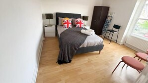 A bedroom with a bed, bedside tables, a wardrobe, and a window. - Brixton Bright Apartment (London)