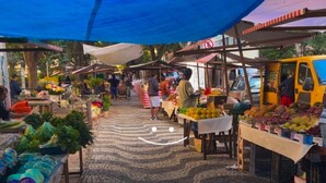 Ein Markt mit Ständen, an denen Obst und Gemüse verkauft werden.
