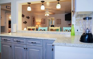 A kitchen with granite countertops, a blender, and a green bottle. - 3 bed/2bath home on quaint Tybee Island 2 blocks to the Beach, 1 Block to food! (Tybee Island)