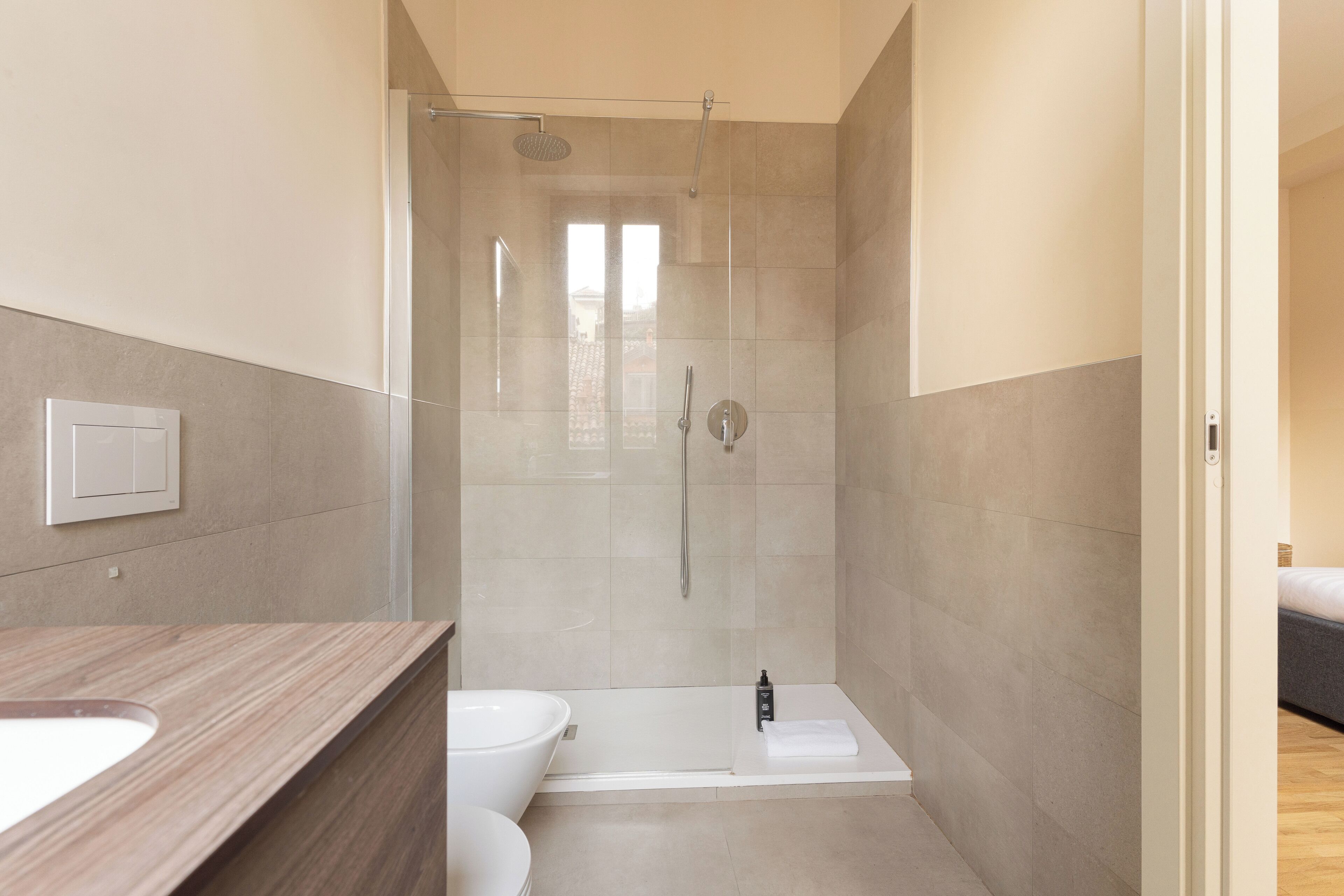 A modern bathroom with a shower, toilet, and bathtub.