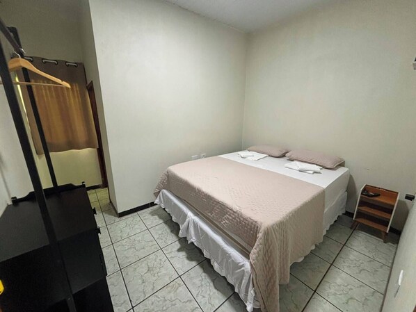 Una camera da letto con un letto, un armadio e un comodino.