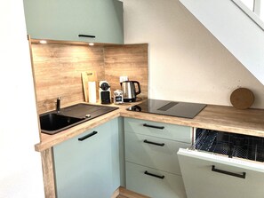 Eine kleine Küche mit Spüle, Arbeitsplatte und Holzausstattung.