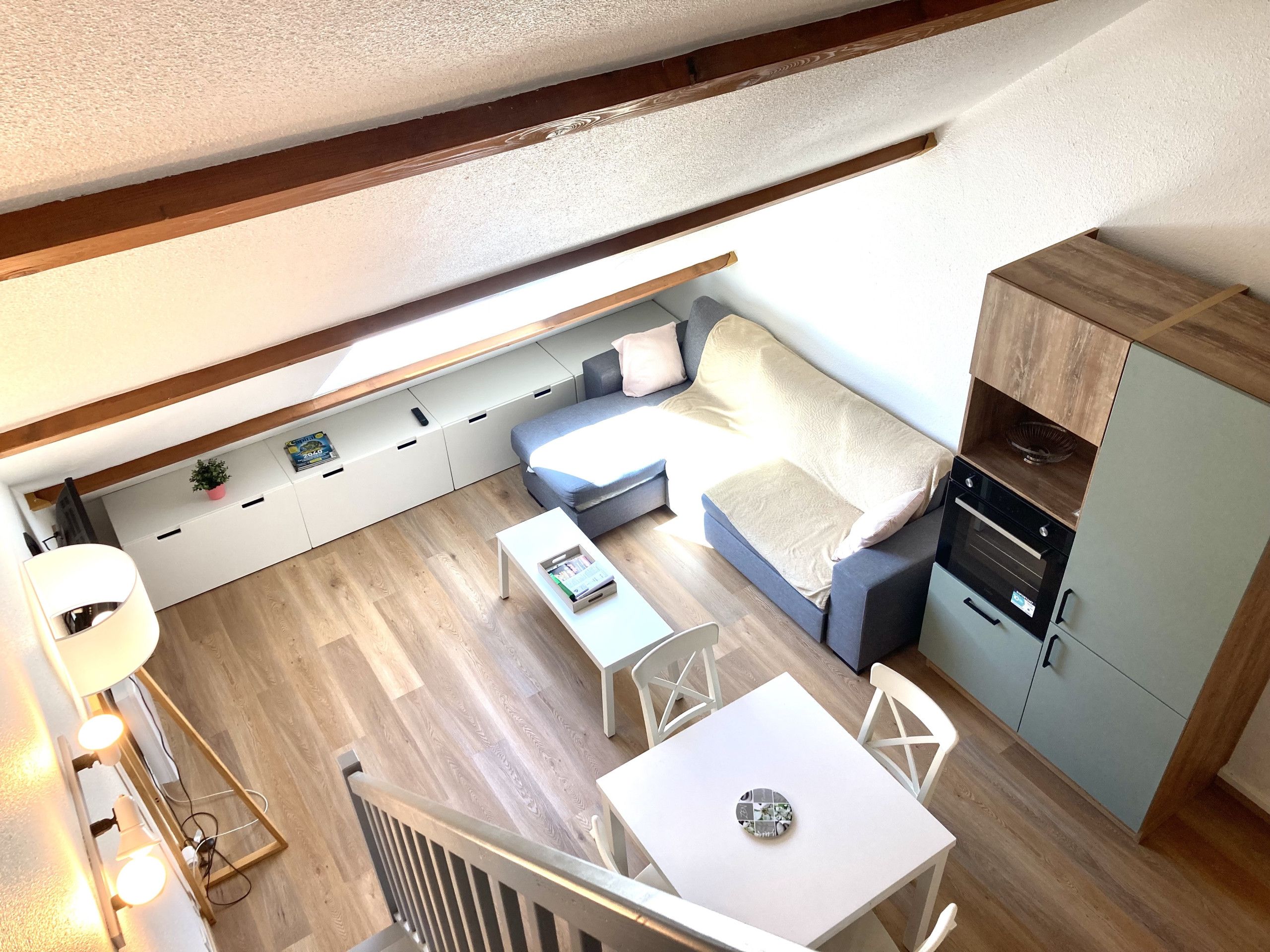 A compact living space with a sofa, a small table, and a cabinet.