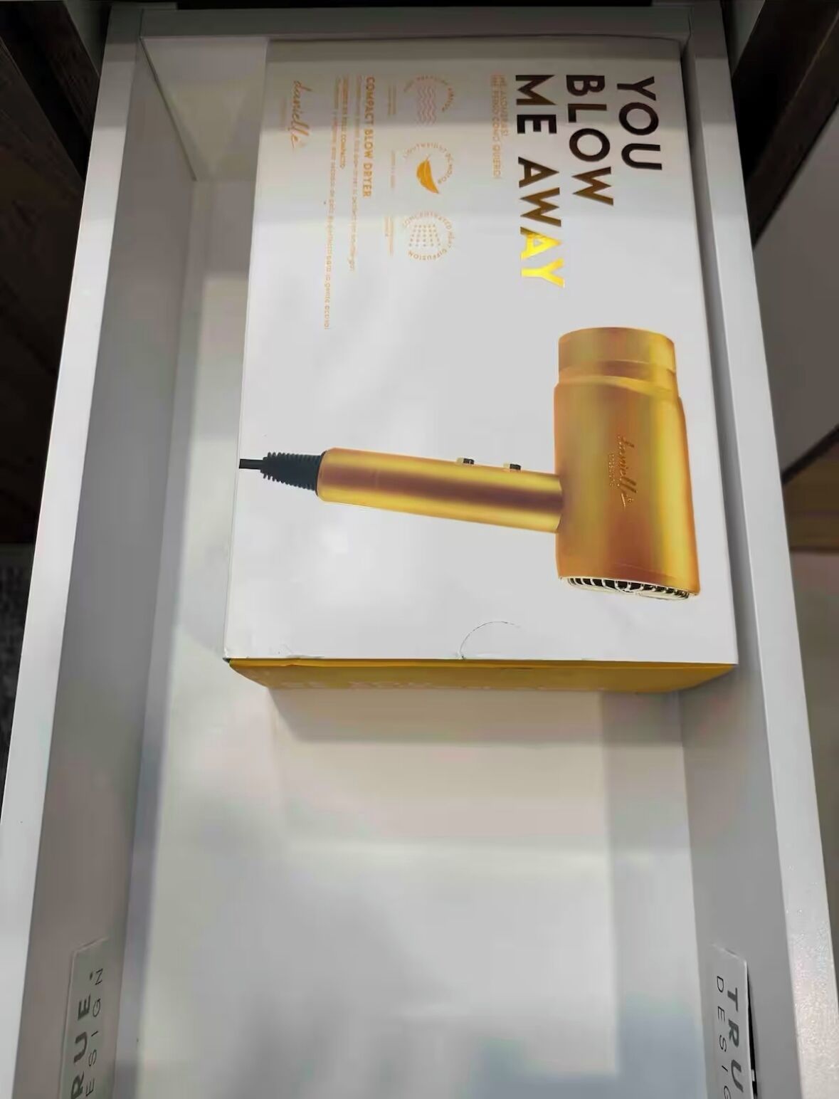 A product box for a hair dryer with the text "YOU BLOW ME AWAY" and a gold-colored hair dryer.