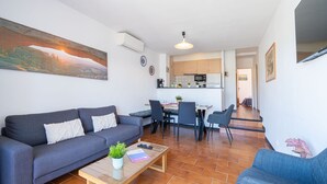 Ein modernes Wohnzimmer mit einer Couch, einem Couchtisch und einem Essbereich mit Stühlen und Tisch.