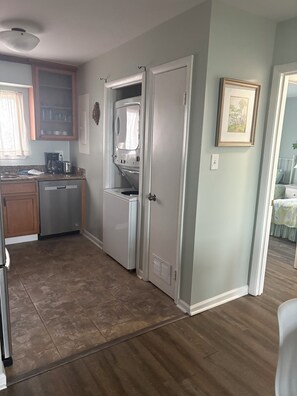 A compact kitchen with a dishwasher, a coffee maker, and a microwave. There is a door leading to another room. - Fantastic beachfront 2-bedroom condo with AC in pleasant Tybee Island (Tybee Island)