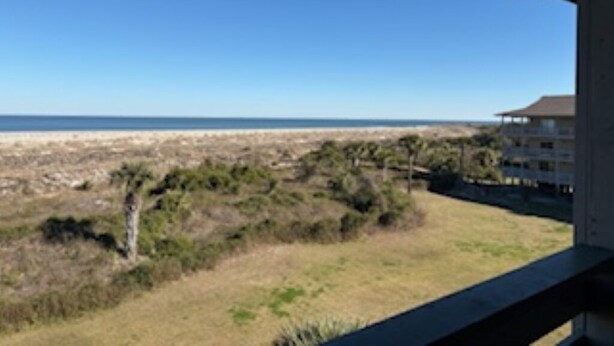 A view from a balcony overlooking a beach with a clear sky. - Fantastic beachfront 2-bedroom condo with AC in pleasant Tybee Island (Tybee Island)
