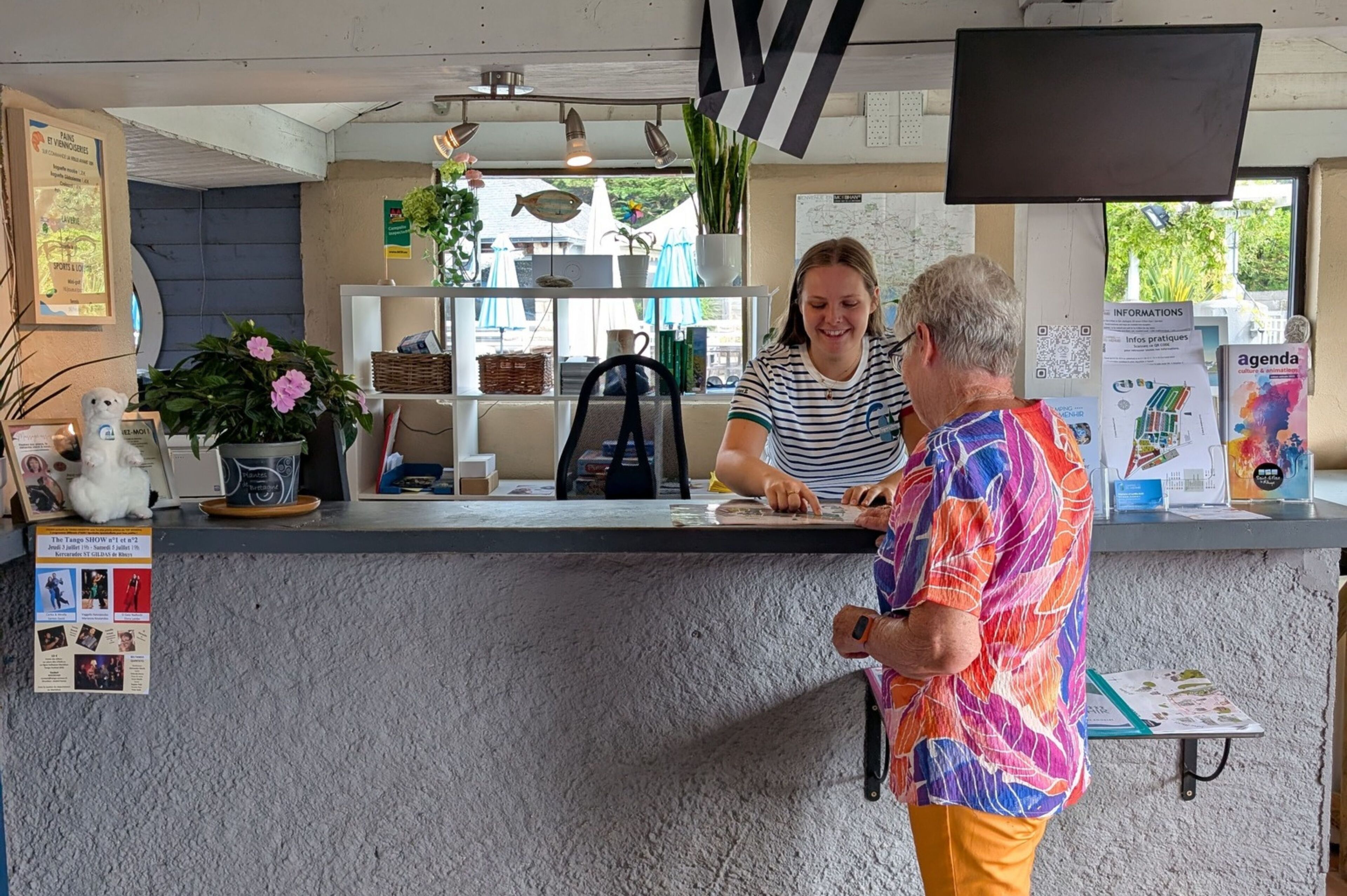 The welcoming reception area at Camping du Menhir features a modern design adorned with vibrant plants, inviting guests to start their relaxing Breton adventure.