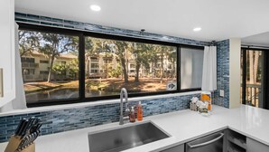A modern kitchen with a large window, a sink, and a knife block. - Seascape Spacious 3 bedroom w/2 Pool walk to Beach, Celebration Park & Coligny! (Hilton Head Island)