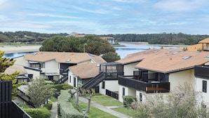 Un quartiere residenziale con case moderne, un percorso ben visibile e un corpo d'acqua sullo sfondo.
