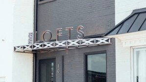 A modern building with a sign that reads 'LOFTS' above the entrance. - Westside Loft (Cookeville)